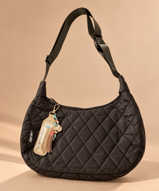A black quilted nylon shoulder bag with a diamond-stitched pattern, featuring a wide adjustable shoulder strap, can be decorated using a keychain or accessories suitable for all day with its waterproof, durable, spacious and lightweight material.  Designed for long workdays, training sessions, gym runs and everything in between.